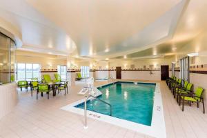 a pool in a hotel with chairs and a table at SpringHill Suites Midland in Midland