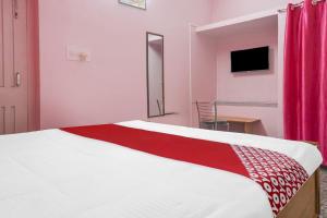 a bedroom with a large bed with a red curtain at OYO Flagship Hotel Kashyap Heritage in Patna