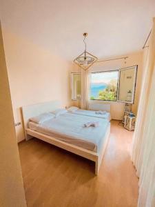 a bedroom with a bed and a large window at Dream Villa in Paleo Tsifliki