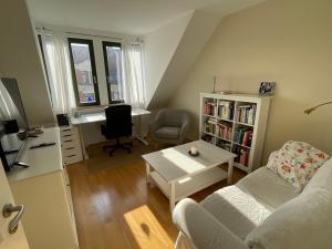 ein Wohnzimmer mit einem Sofa, einem Tisch und einem Schreibtisch in der Unterkunft Loft mit 2 Terrassen - ruhig&sonnig in Leipzig