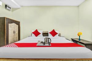 a bedroom with a large white bed with red pillows at OYO Flagship Govind Guest House in Gorakhpur