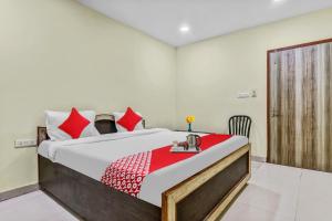 a bedroom with a large bed with a red blanket at OYO Flagship Govind Guest House in Gorakhpur