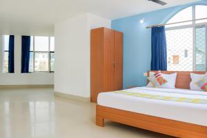 Un dormitorio con una cama grande y una ventana en OYO Home Elite Stay Near Shri Shri Shiridi Sai Mandir, en Khandagiri