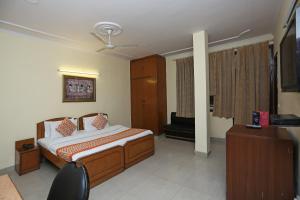 a bedroom with a bed and a television in it at Hotel O Kalkaji Residency Bnb Near Lotus Temple in New Delhi +23 photos