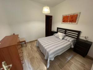 um quarto com uma cama, uma cómoda e um candeeiro em Apartamento Duplex El Porche em Paradas