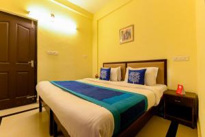 a bedroom with a large bed with blue and white pillows at Super OYO Flagship Hotel Diamond In in Kakkanad
