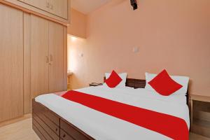 1 dormitorio con 1 cama grande con almohadas rojas en Highways Residency, en Madurai