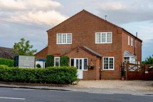 a brick house with a sign in front of it at Grapevine Getaway in Lincolnshire