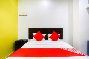 ラーイプルにあるOYO Raipur Innのベッドルーム1室(赤と白の枕が備わるベッド1台付)