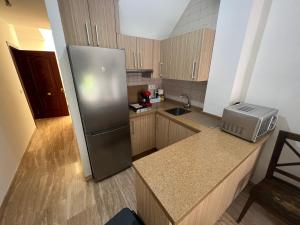 uma cozinha com um frigorífico de aço inoxidável e armários de madeira em Apartamento Duplex El Porche em Paradas