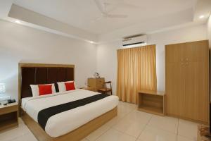 a bedroom with a large bed with red pillows at Edasserys Kalamassery Tourist Home in Elūr