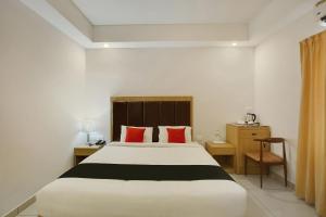 - une chambre avec un grand lit et des oreillers rouges dans l'établissement Edasserys Kalamassery Tourist Home, à Elūr