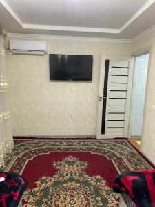 sala de estar con TV de pantalla plana en la pared en MehmonServis1, en Samarkand
