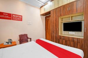 um quarto com uma cama e uma televisão de ecrã plano em OYO Pratikshya A1 Residency em Bhubaneshwar
