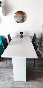 a white table in a room with chairs at Regina del Bosco della vicina Cavalese in Daiano