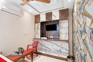 uma sala de estar com uma televisão na parede em OYO Pratikshya A1 Residency em Bhubaneshwar