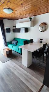 salon z zieloną kanapą i stołem w obiekcie Regina del Bosco della vicina Cavalese w mieście Daiano