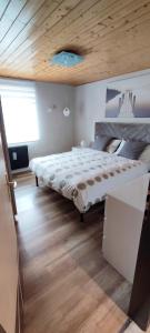 sypialnia z dużym łóżkiem i drewnianym sufitem w obiekcie Regina del Bosco della vicina Cavalese w mieście Daiano