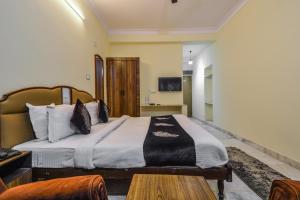 a bedroom with a large bed and a table at Hotel Vinayak in Udaipur