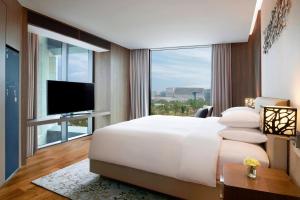 a bedroom with a large white bed and a large window at Courtyard by Marriott Seoul Botanic Park in Seoul