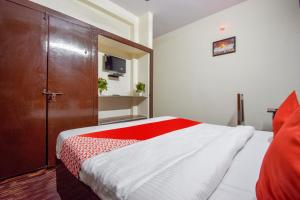 a bedroom with a bed and a wooden door at OYO Hotel Shiv Shakti in Jaipur