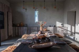 un lungo tavolo in legno con cibo sopra in una stanza di Chambres de Gilberoux a Floreffe