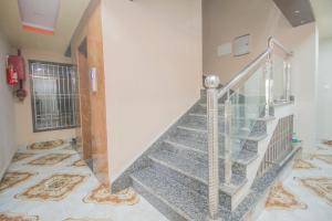 una escalera en una casa con barandilla de cristal en Hotel Stay In en Kuch Bihār