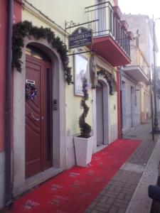 um tapete vermelho em frente a um edifício com uma porta em B&B Palatium S.G. em Palazzo San Gervasio
