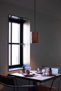 Floreffe的住宿－Chambres de Gilberoux，一张桌子,上面有盘子和杯子,还有一个窗口