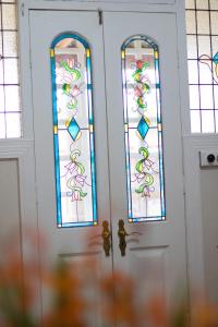 a pair of doors with stained glass windows at Oude Post Guesthouse and Cottage - The Old Postmaster's House in Lydenburg