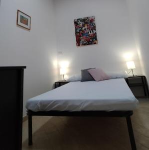 a bed in a room with two lamps on two tables at La Casina Tuttomondo in Viareggio