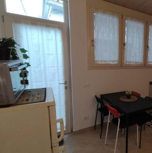 a kitchen with a table and a black table and chairs at La Casina Tuttomondo in Viareggio