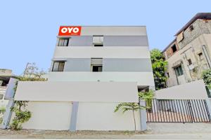 ein weißes Gebäude mit einem Schild davor in der Unterkunft Hotel O Happy Stay in Méribel Village