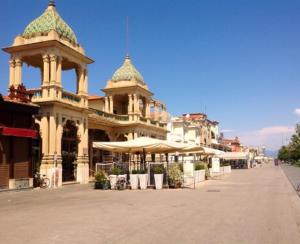 a building with umbrellas and tables on a street at La Casina Tuttomondo in Viareggio