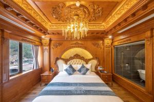 a bedroom with a large bed and a chandelier at Glenda Tower Moc Chau Hotel in Mộc Châu