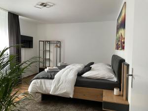 sypialnia z łóżkiem w białym pokoju w obiekcie - SANO Apartments - Stilvoll - Ruhig - Platz zum Arbeiten w mieście Hagen