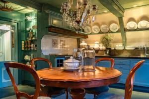 una cocina con una mesa de madera con sillas y una lámpara de araña en De Ginkgo in het hart van Hoorn en Hoorn