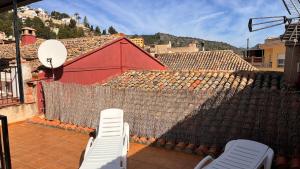two white chairs sitting on a tile roof at Casa Rural Josep in Ador