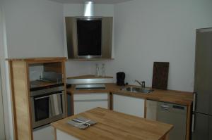 a small kitchen with a sink and a table at Skagen City Apartments in Skagen