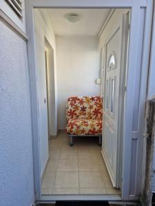 a hallway with a chair and a door at Studio apartman Altea in Stinica