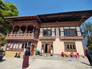 Eine Frau, die vor einem Haus steht. in der Unterkunft Mendrelgang Homestay in Punākha