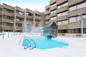 ein Schwimmbad im Schnee vor einem Gebäude in der Unterkunft Delta Hotels by Marriott Quebec in Québec