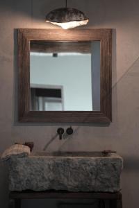 a bathroom with a mirror and a stone sink at Chambres de Gilberoux in Floreffe