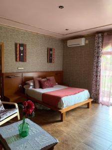 Apartamento rural FRAGARIA في Casas del Monte: غرفة نوم بسرير كبير وطاولة