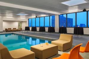 a pool room with chairs and tables and chairs and a table and chairsktopktop at Aloft South Bend in South Bend