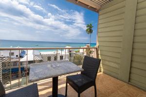 a balcony with a table and chairs and the ocean at Caribic House in Montego Bay