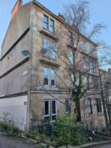 an old brick building with a tree in front of it at Garnethill Upper in Glasgow