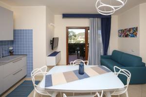 kuchnia i salon ze stołem i kanapą w obiekcie Swimming Pool and Relax Apartment w mieście Castelsardo