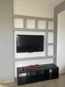a living room with a flat screen tv on a wall at Airport View Apartments in Artemida