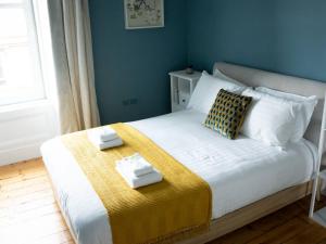 a bedroom with a bed with two towels on it at Garnethill Upper in Glasgow